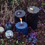 Beltane magic ritual with burning candles, crystals and magic objects outside.