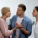 Young man settling conflict between mother and wife, family problems, quarrel